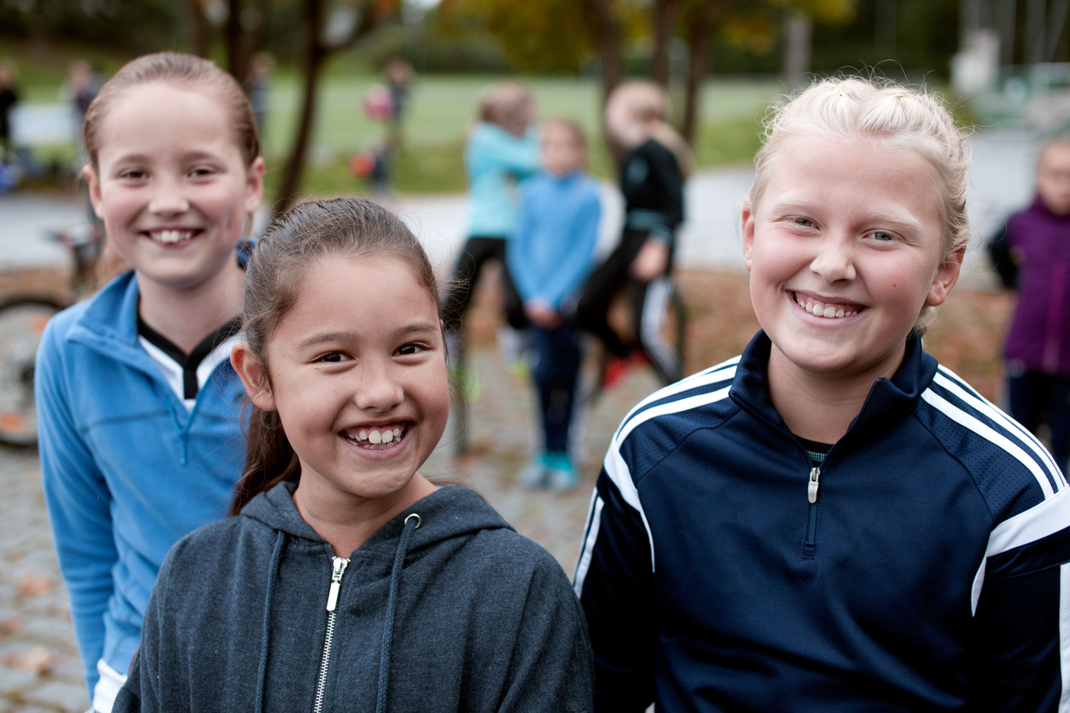 Bilde av tre jenter som smiler til kamera