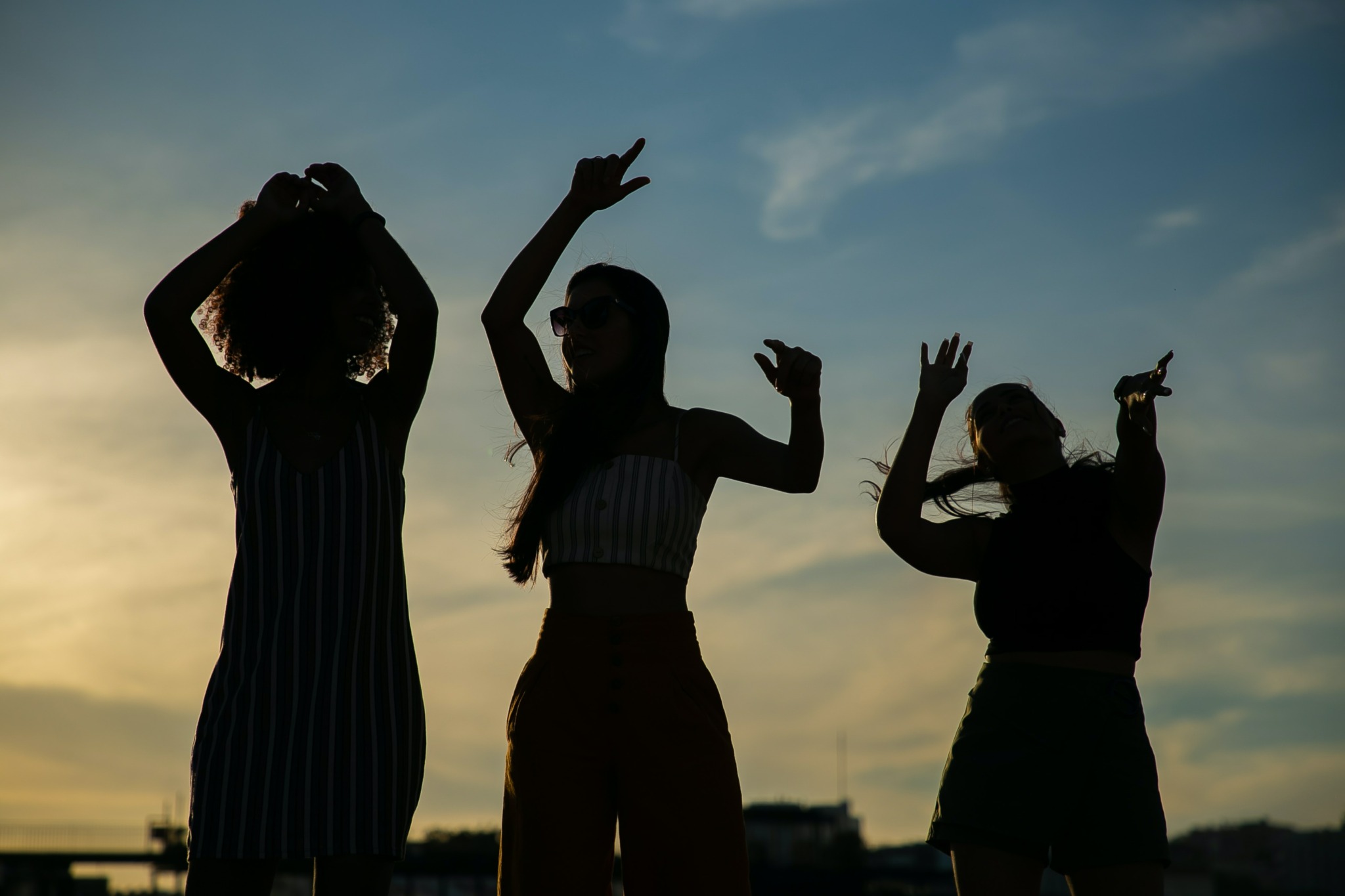 konturene av tre kvinner som danser med himmelen i bakgrunnen