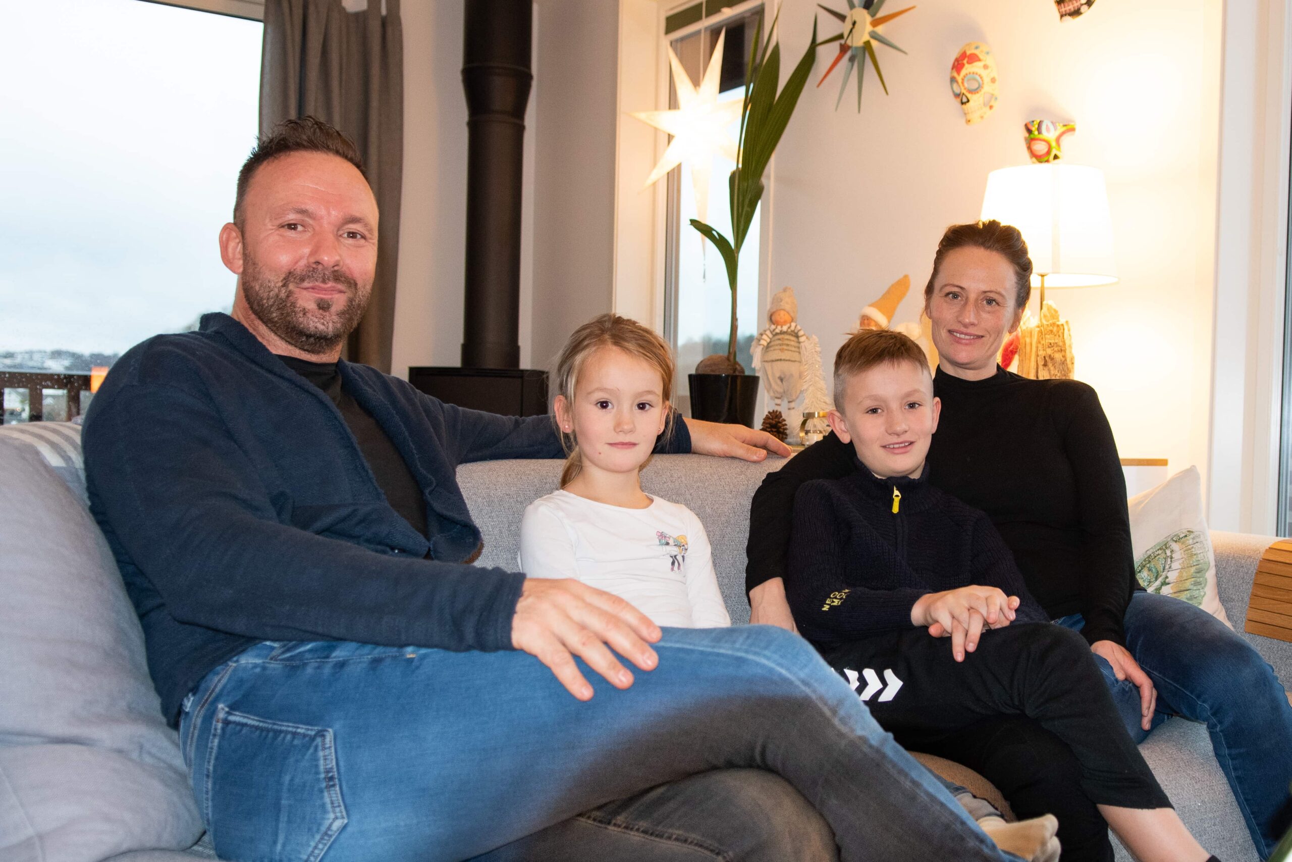 Familien Morsdal smiler opp mot kamera. 2 voksens og 2 barn.