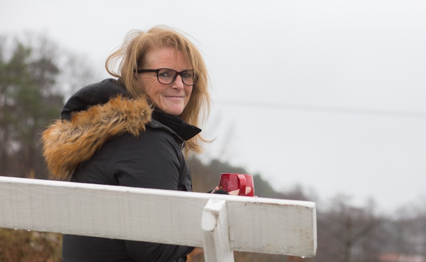 Moren til Susanne som sitter på en benk og det er en grå dag