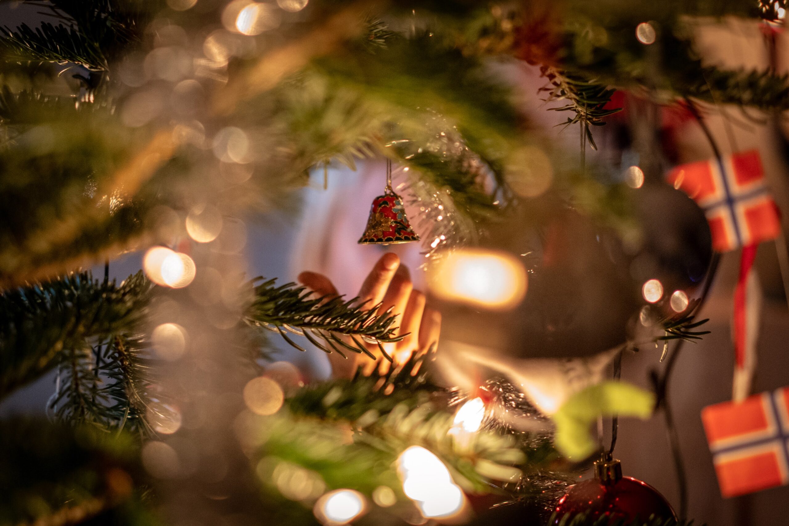 En barnehånd som strekker seg mot julepynten. 