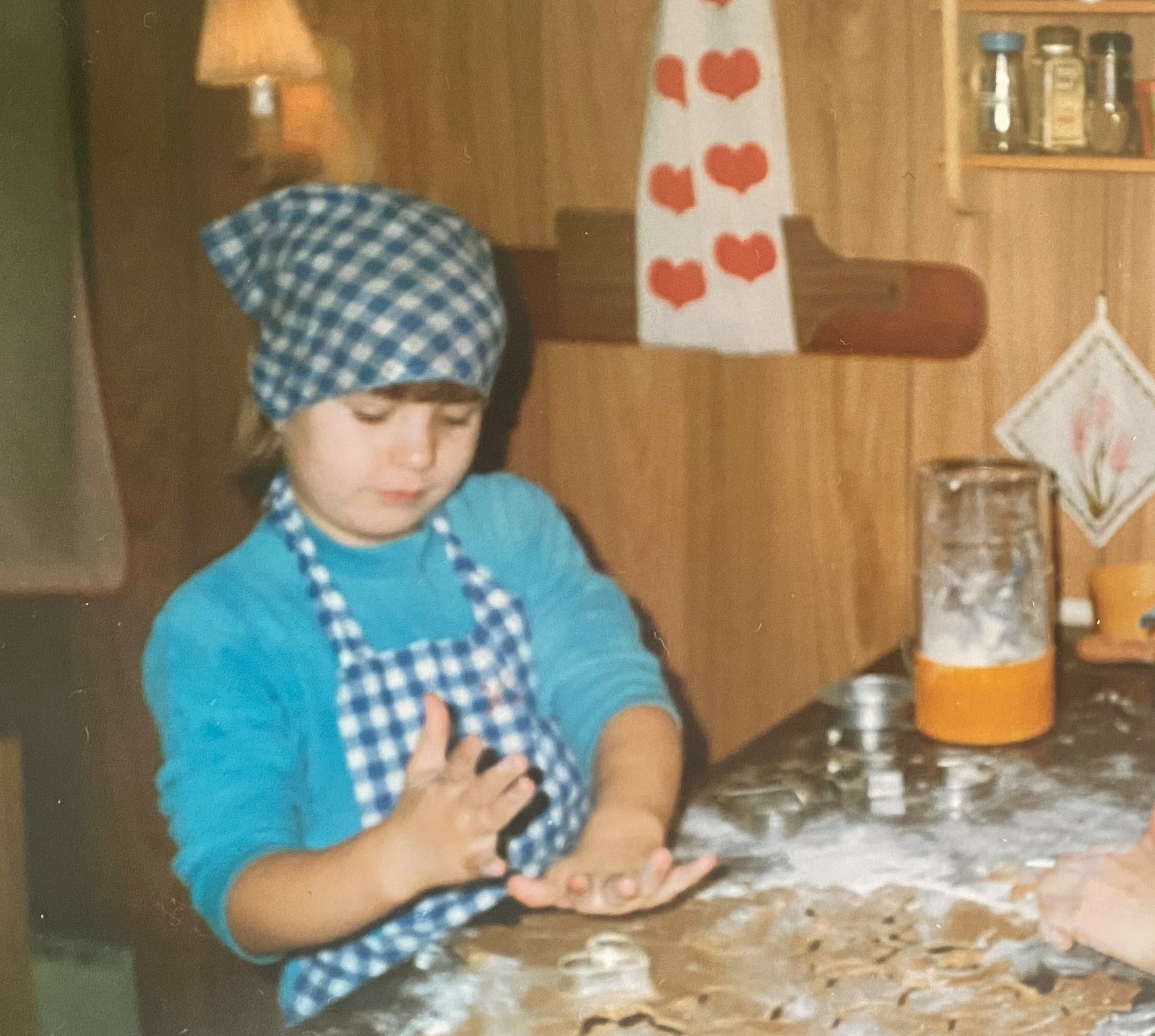 Maria som står og baker julekaker med tørkle på hodet og forkle.