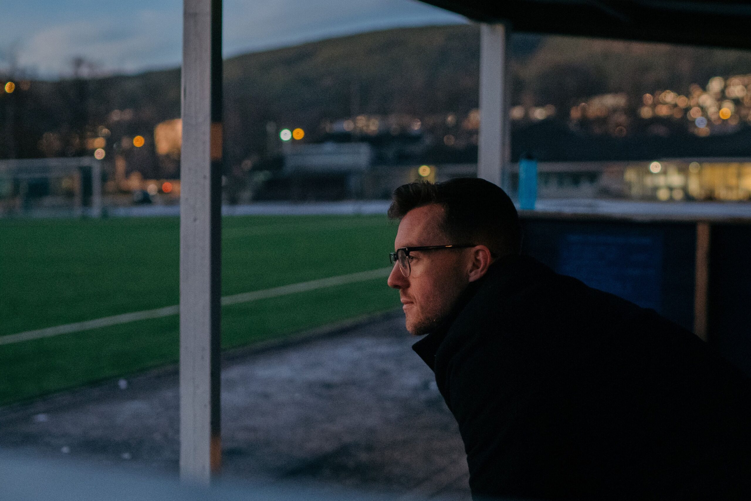 Ole Tobias sitter og ser utover fotballen i mørket som voksen