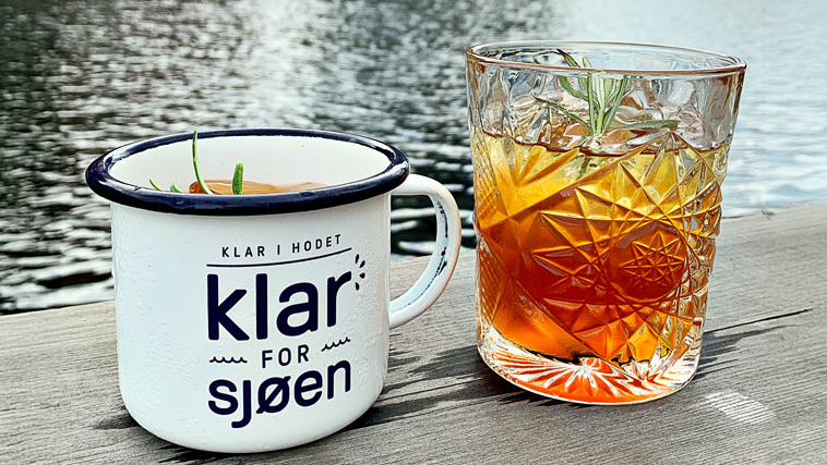 Bilde av en Cold Fashioned alkoholfri drink i et kopp og et glass på bryggekanten