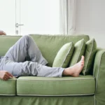Bilde av nedre del av en mann som ligger henslengt i en sofa