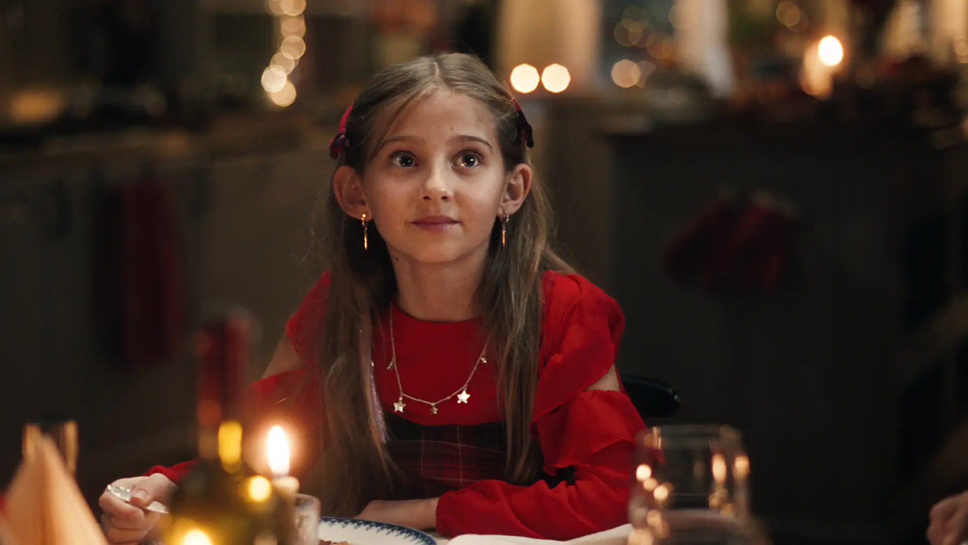 Julepyntet jente ser opp med et håpefullt uttrykk i ansiktet.