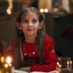 Julepyntet jente ser opp med et håpefullt uttrykk i ansiktet.