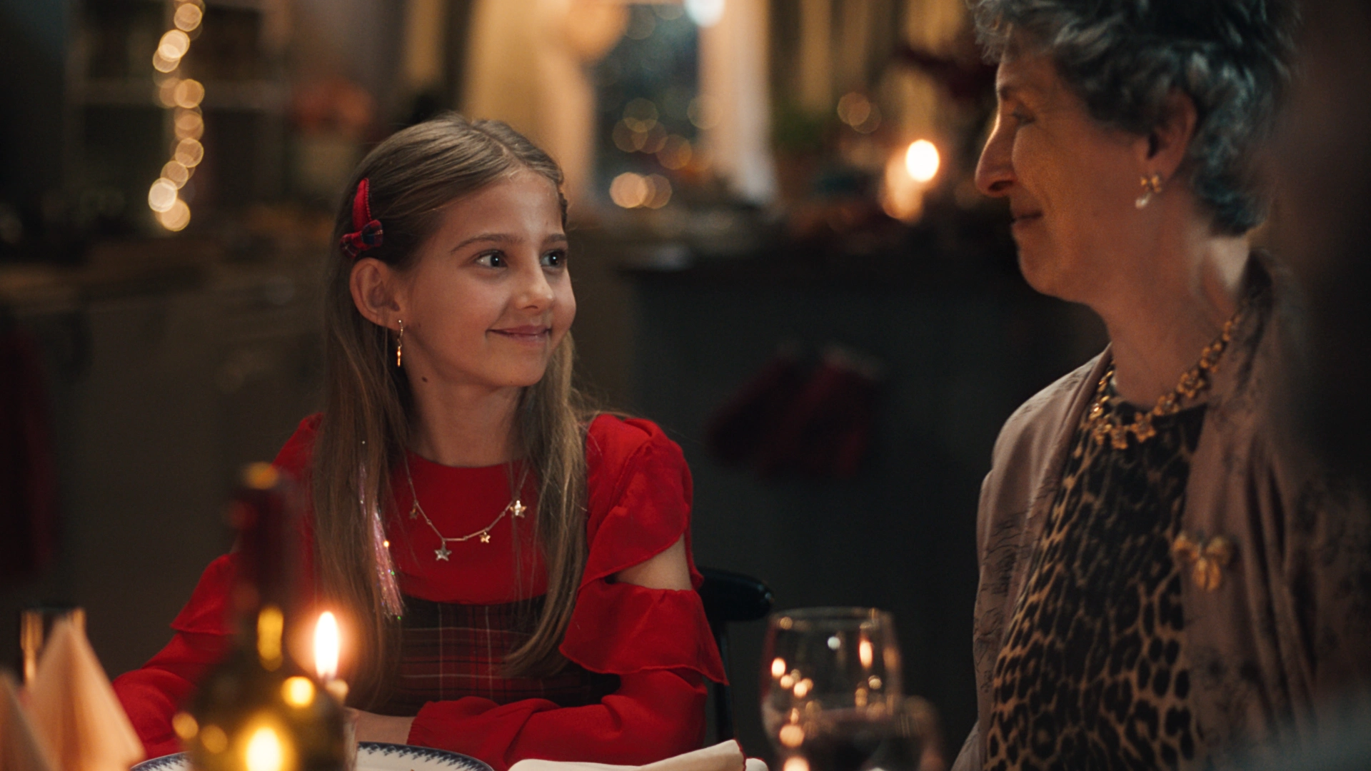 Julepyntet jente og tante ser på hverandre med varmt blikk.