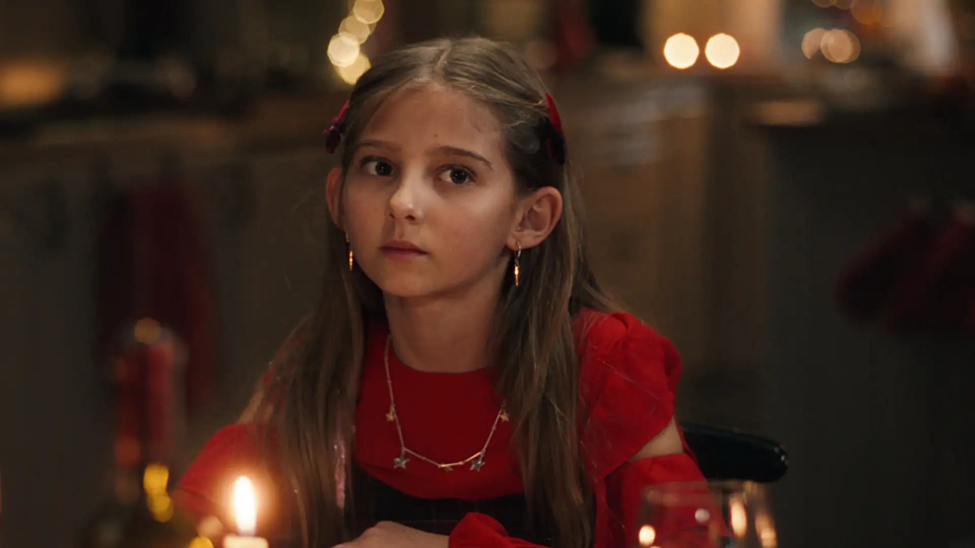 Julepyntet jente ser til siden med et tenksomt blikk.