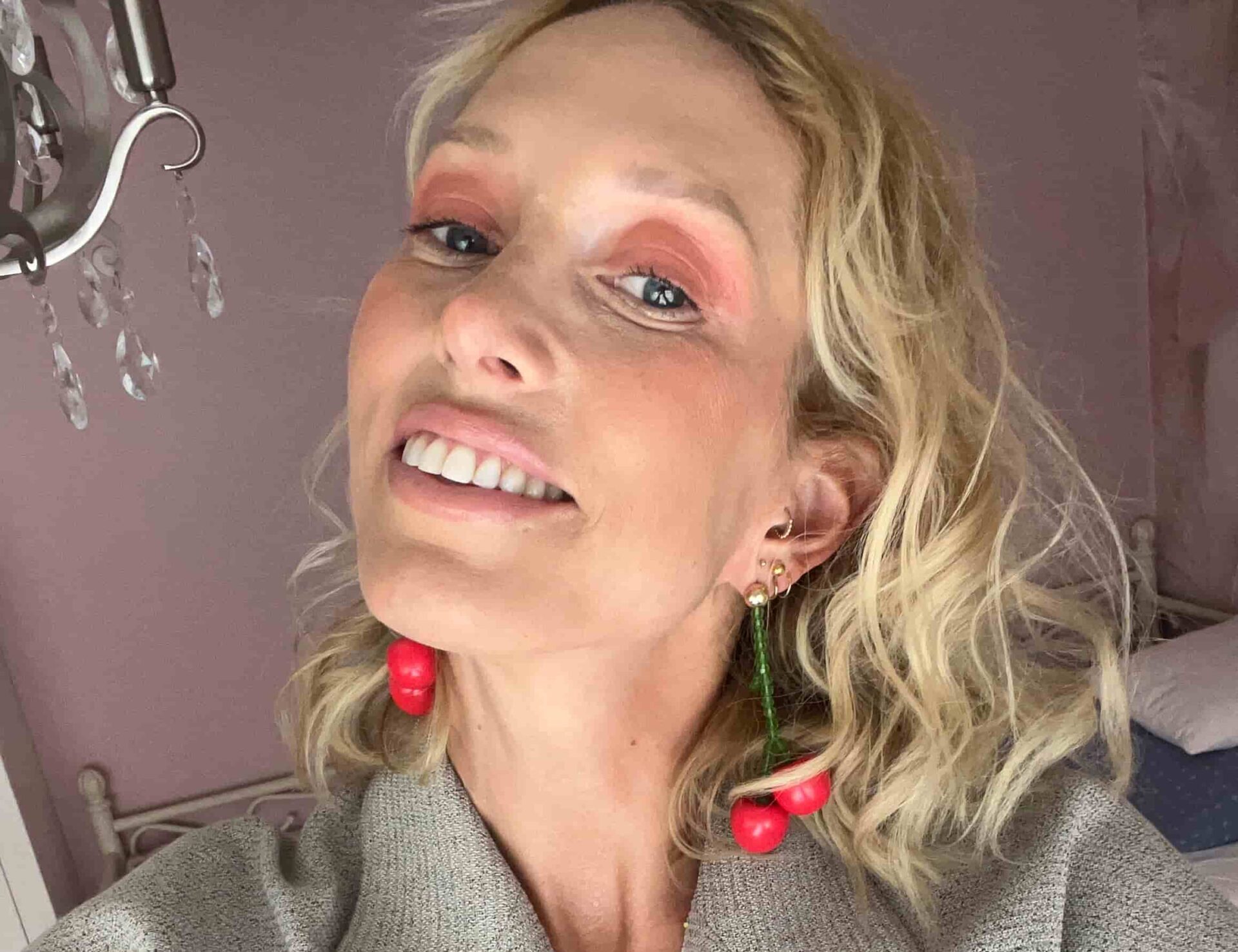 Kjerstin ser inn i kamera, med fargerik sminke og store øredobber