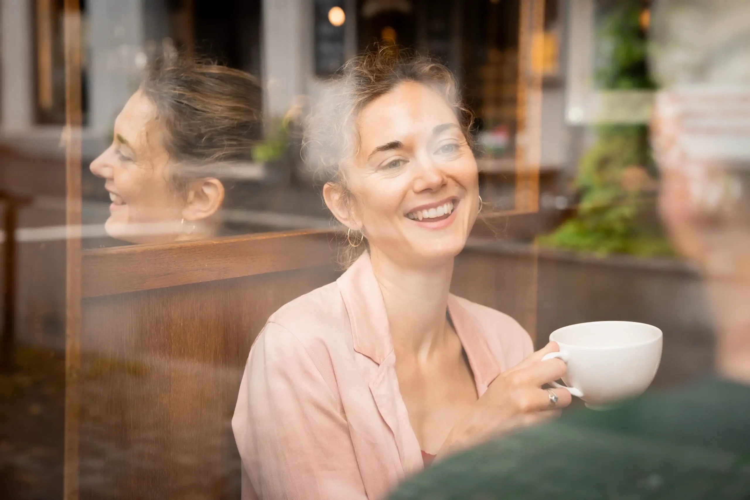 Portrett av psykolog og sexolog Elisabeth Tverrli som sitter på kafé og drikker av en kopp.