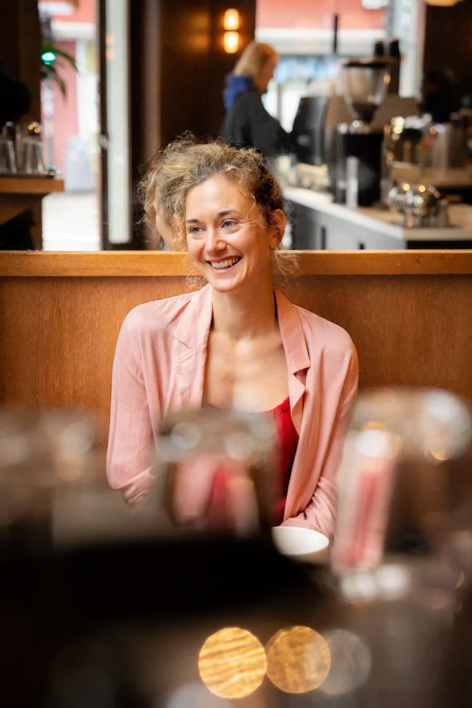 Portrett av psykolog og sexolog Elisabeth Tverrli som sitter på kafé og smiler.