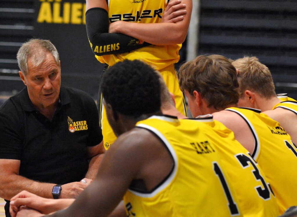 Per Tøien står og snakker til tre basketspillere. 