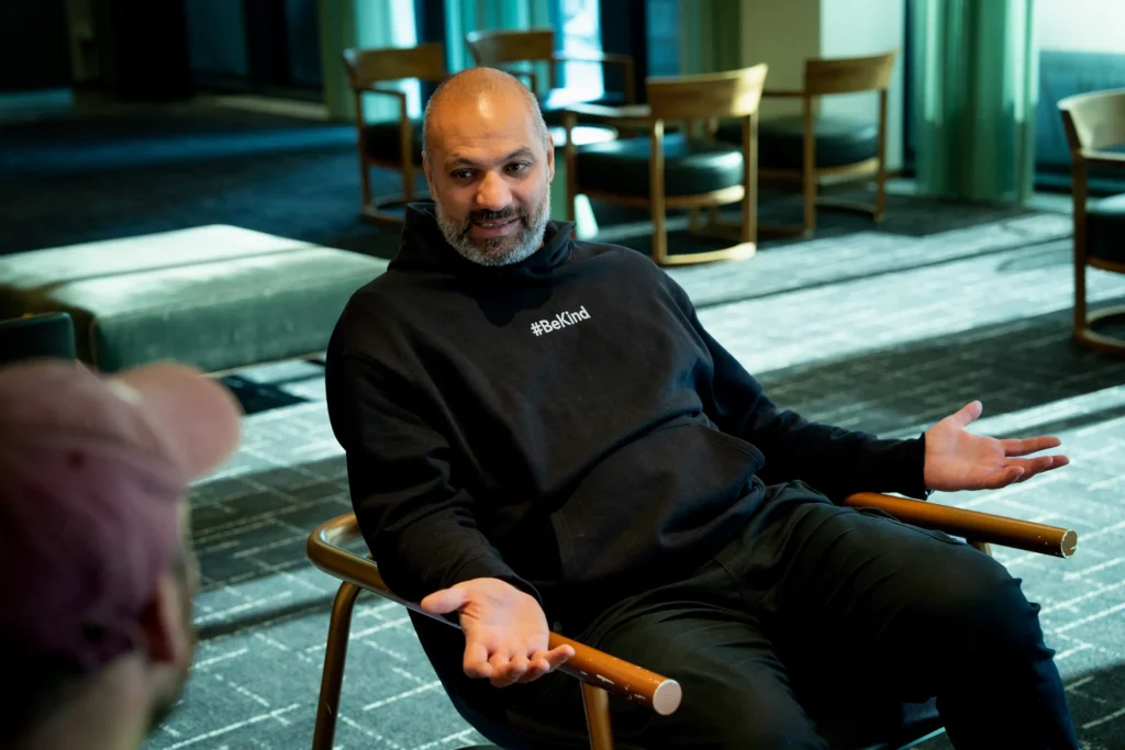 Marco Elsafadi sitter i en stol og gestikulerer med hendene mens han forteller.