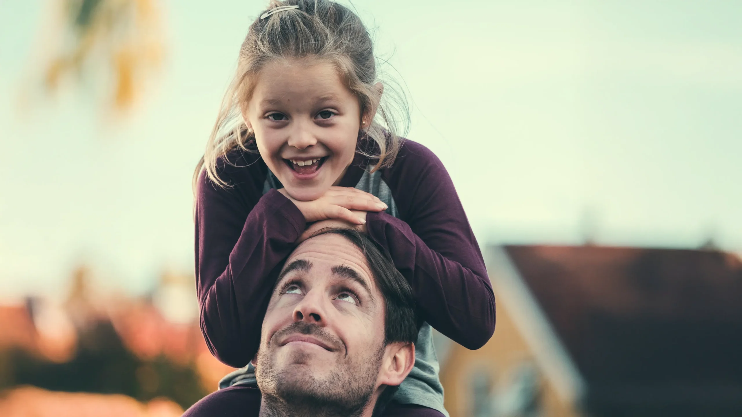 Barn sitter på farens skuldre