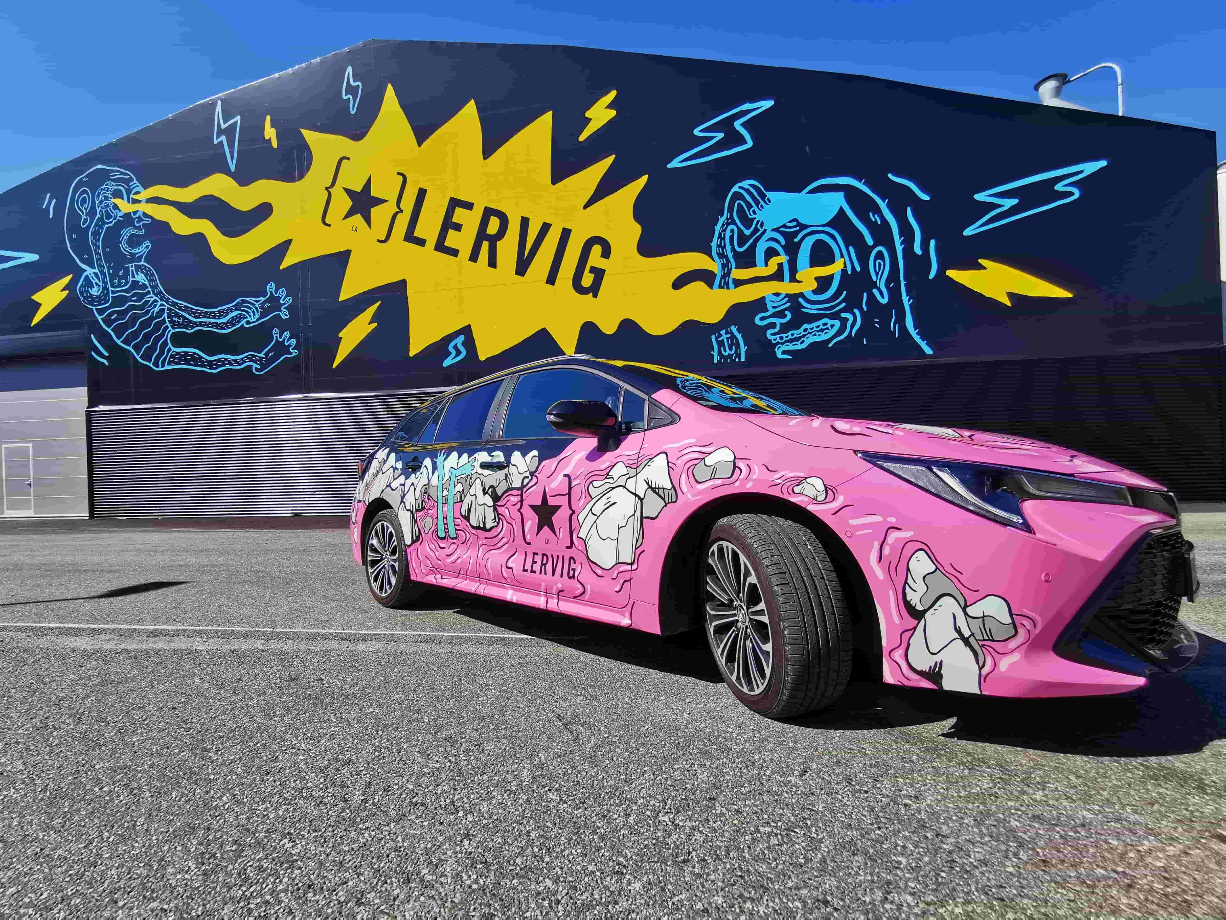 Rosa sportsbil med Lervigs design og logo på, står foran bryggeriet til Lervig.