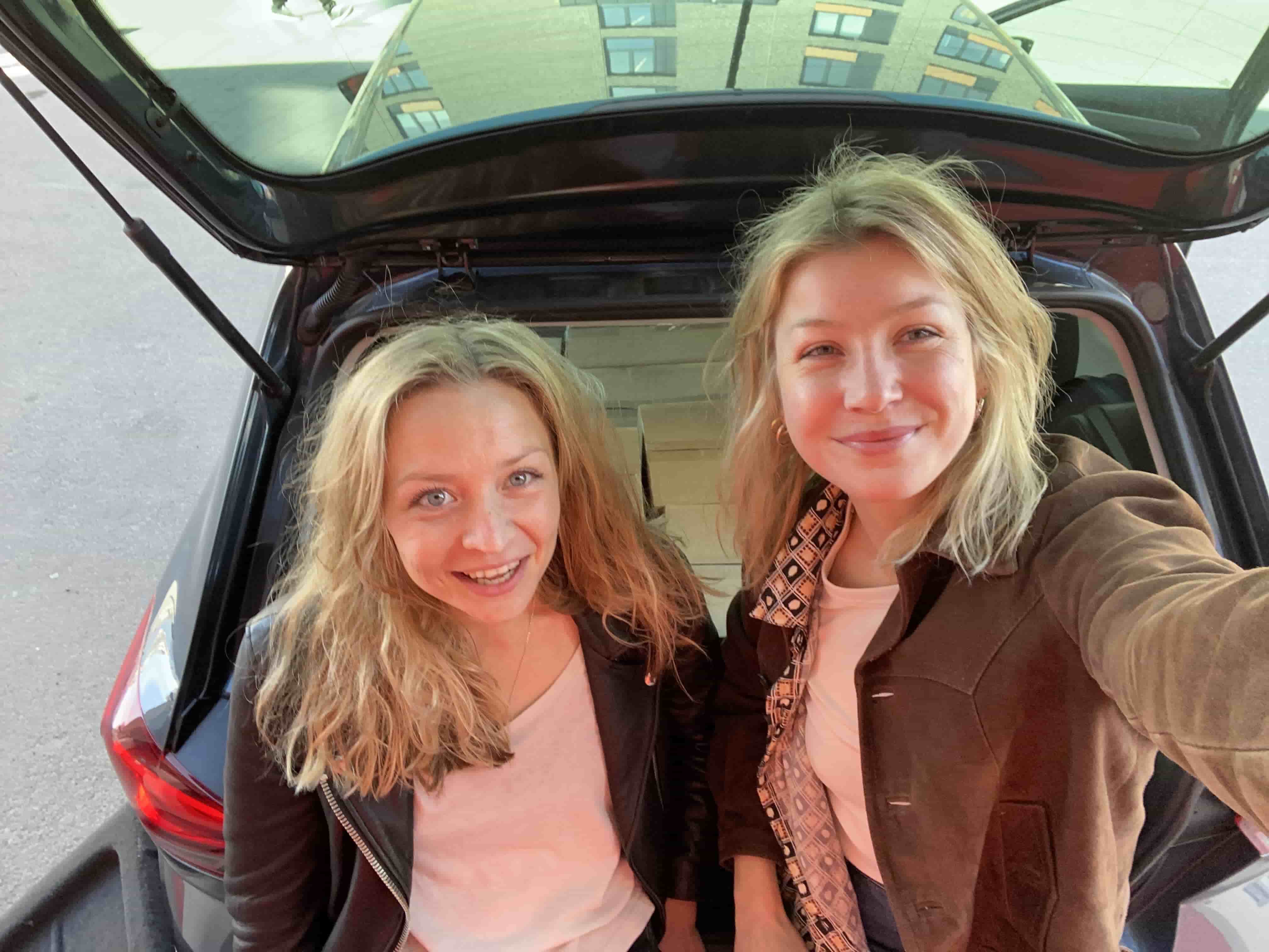Selfie av gründer Vanessa og Cornelia foran baggasjerommet på bilen, fylt med pakker med Villbrygg klar til levering.