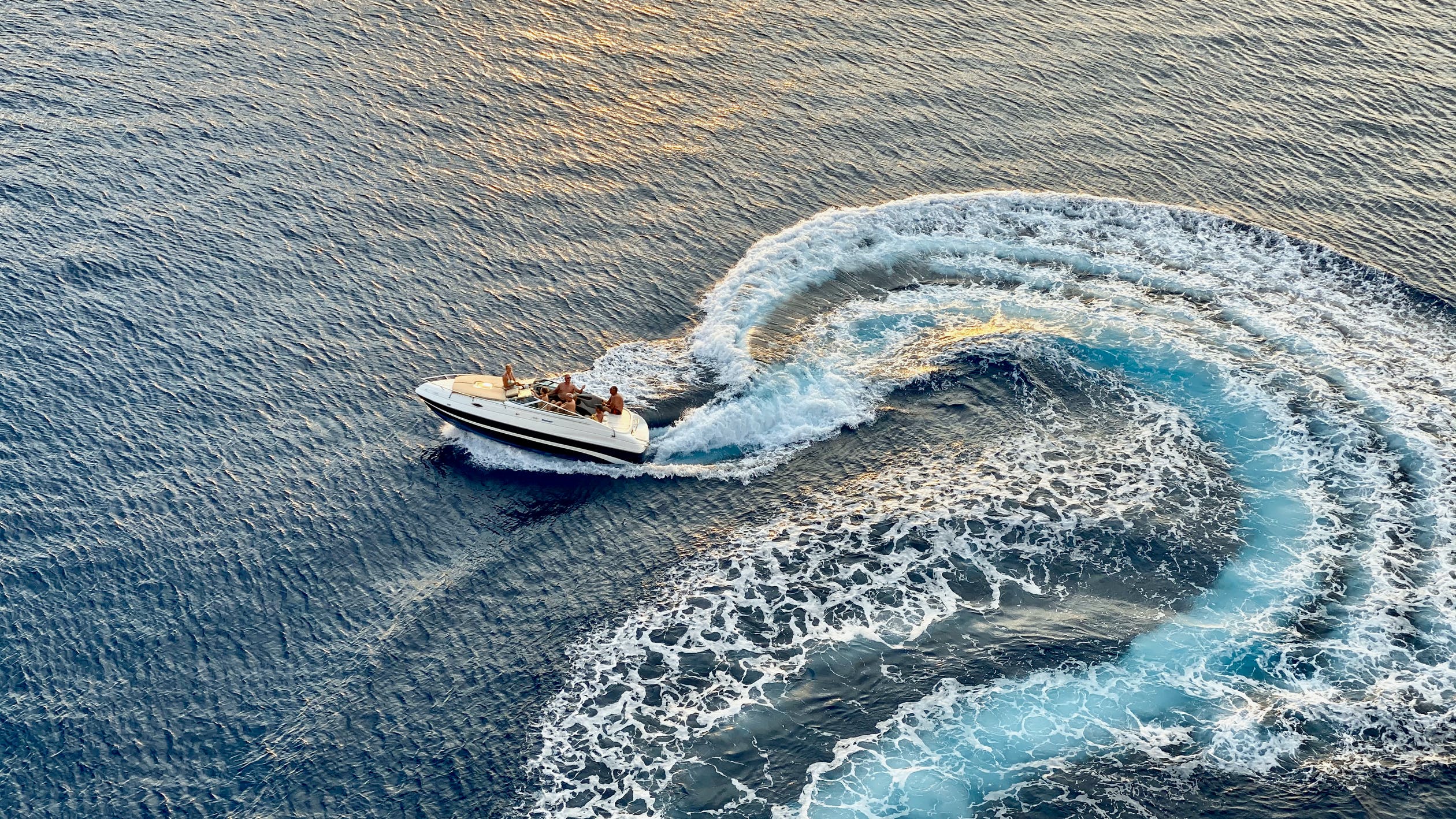En dagscruiser ute på sjøen en fin sommerdag. Vi ser mennesker som koser seg sammen i båten.