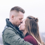 Bilde av et kjærestepar hvor mannen kysser dama si på panna