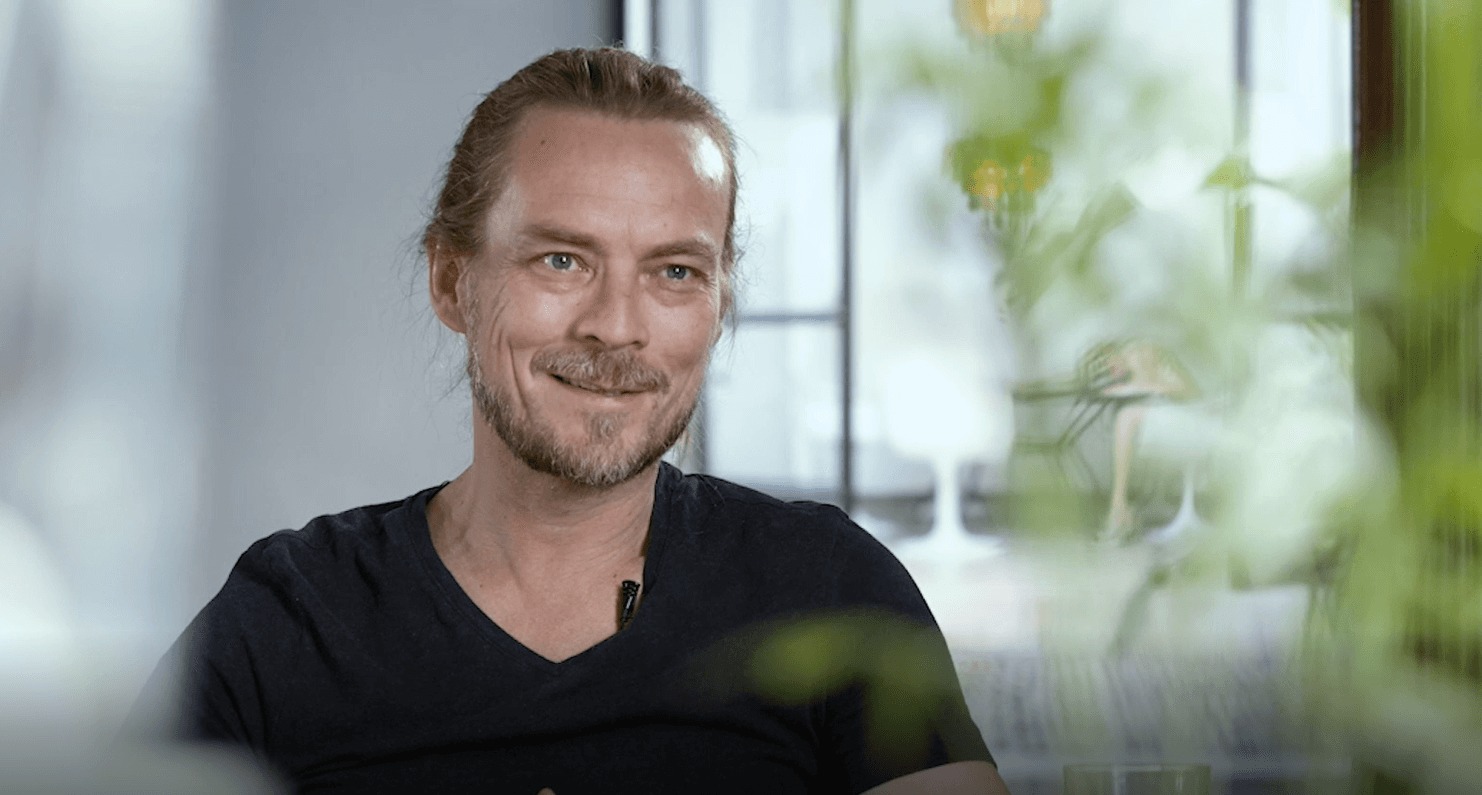 Psykolog Peder Kjøs har på svart t-skjorte og håret samlet i en hestehale.