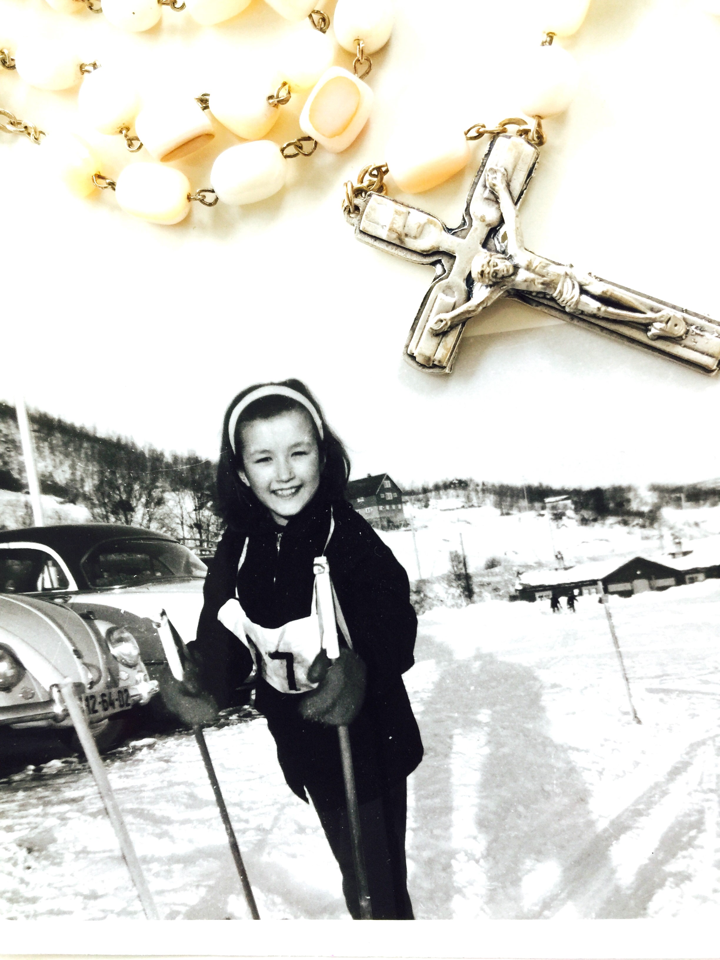 Svart-hvitt bilde av Gunn-Helen som barn. Hun står på ski, har startnummer på brystet og smiler inn i kamera.