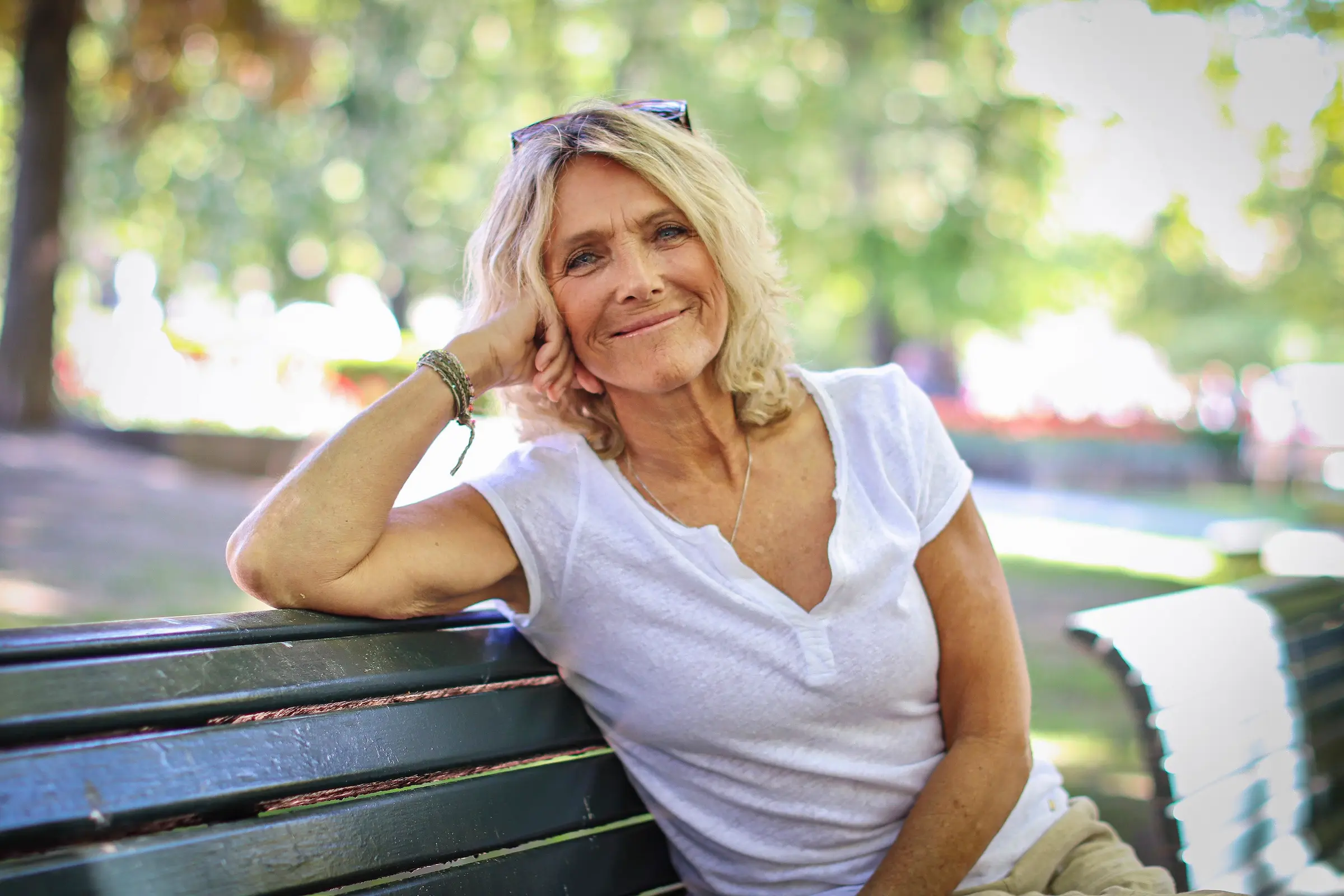 Bilde av Trude Vasstrand som smiler til kamera i sommerlige omgivelser